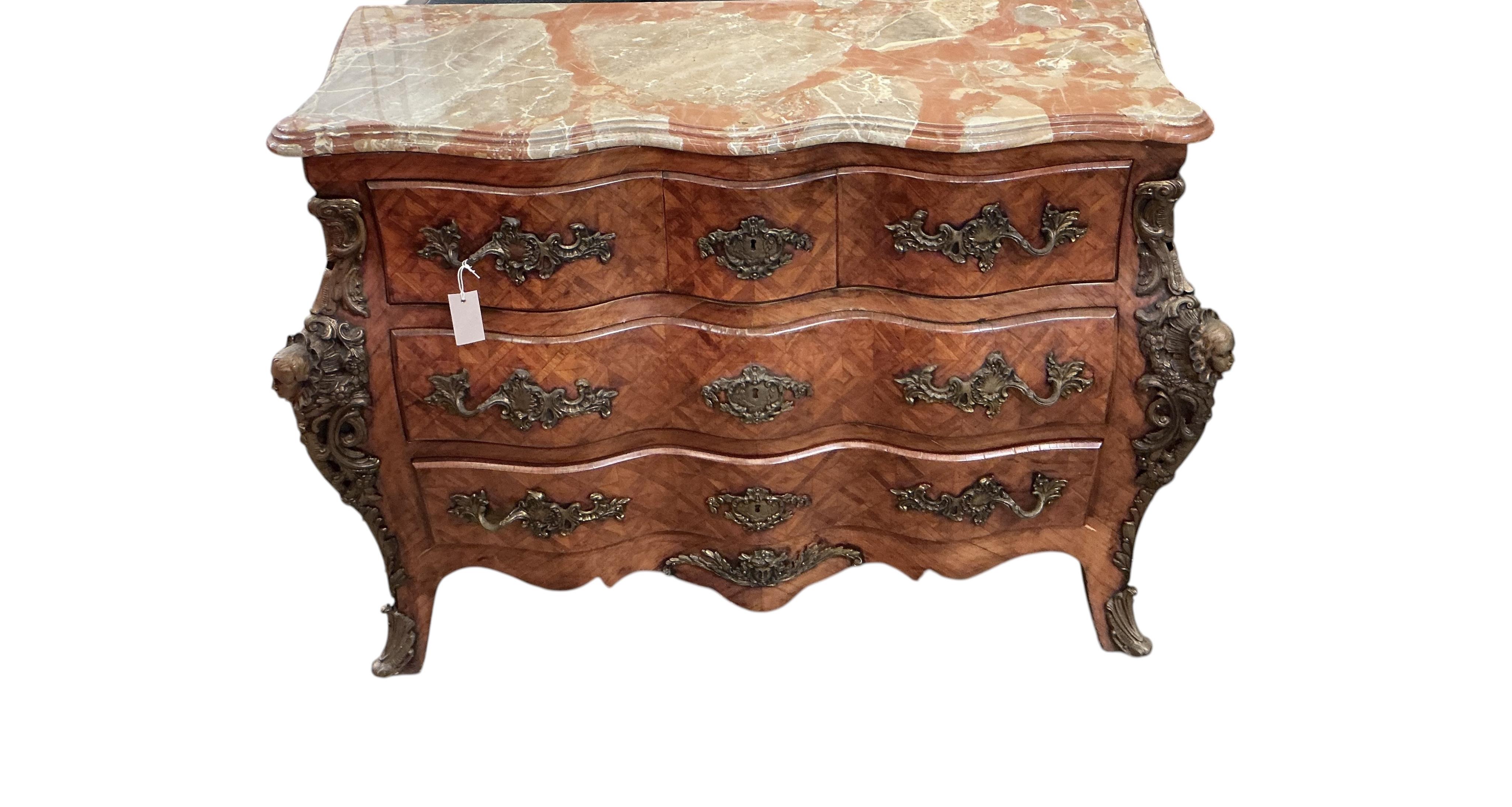 A French transitional style gilt metal mounted onyx top bombe commode, width 114cm, depth 47cm, height 88cm